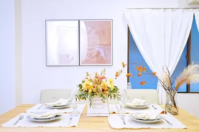 a dining room table with plates and flowers on it at Bohemian Tokyo in Tokyo