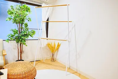 a room with a white wall and two plants at Bohemian Tokyo in Tokyo
