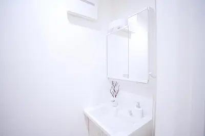 a white bathroom with a sink and a mirror at Bohemian Tokyo in Tokyo