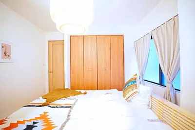 a bedroom with a bed and a wooden cabinet at Bohemian Tokyo in Tokyo