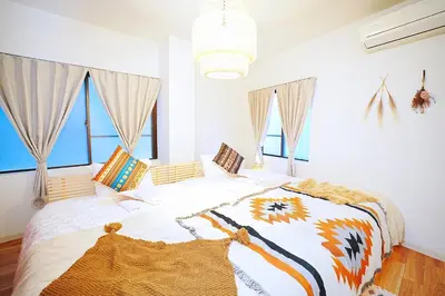 a bedroom with a bed with white walls and windows at Bohemian Tokyo in Tokyo