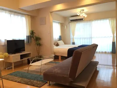 a living room with a bed and a couch at Village Gotanda in Tokyo