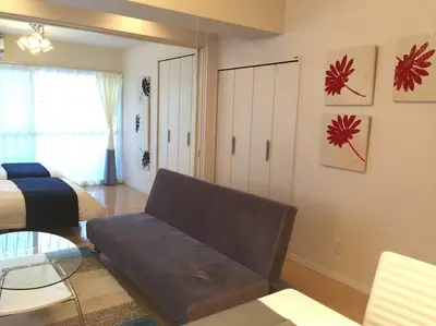 a living room with a couch and a bed at Village Gotanda in Tokyo