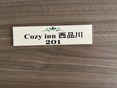 a white tag on a wooden table at Cozy INN \u897f\u54c1\u5ddd201 in Tokyo
