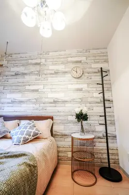 a bedroom with a brick wall with a bed and a clock at B3f\u6c60\u888b\u4e2d\u5fc3 \u4e24\u5ba4 \u4ea4\u901a\u4fbf\u5229 \u8f66\u7ad93\u5206\u949f 2 rooms Ikebukuro center 3 mins to ST Max 5P \u76f4\u8fbe\u65b0\u5bbf \u6d89\u8c37 \u8868\u53c2\u9053 \u6c60\u888b \u4e0a\u91ce \u4ee3\u4ee3\u6728 \u94f6\u5ea7 \u539f\u5bbf in Tokyo