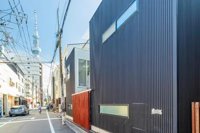 a black building on the side of a street at Pufuka Mukojima 1 in Tokyo