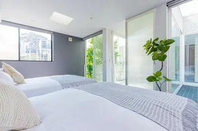 a bedroom with a white bed and a potted plant at Pufuka Mukojima 1 in Tokyo