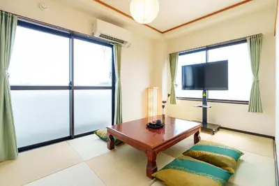 a living room with a table and a tv at \u9759\u5fc3\u5bbfTranquil Retreat 4F\u6674\u7a7a\u5854\u76f4\u8fbe\u4e1c\u4eac\u6cb3\u666f\u6c11\u5bbf in Tokyo