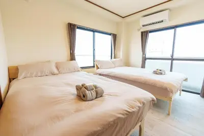 two beds in a room with a stuffed animal on them at \u9759\u5fc3\u5bbfTranquil Retreat 4F\u6674\u7a7a\u5854\u76f4\u8fbe\u4e1c\u4eac\u6cb3\u666f\u6c11\u5bbf in Tokyo