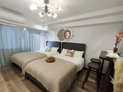 a bedroom with two beds and a table and a mirror at S43 Shibuya center 5 mins to St, Max 4P \u6d89\u8c37\u6700\u4e2d\u5fc3 \u6d89\u8c37\u7ad95\u5206-S \u76f4\u8fbe\u8868\u53c2\u9053 \u6c60\u888b \u4e0a\u91ce \u4ee3\u4ee3\u6728 \u94f6\u5ea7 \u539f\u5bbf in Tokyo