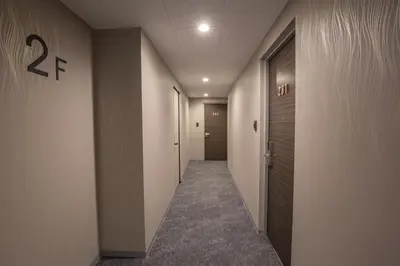 a corridor of a hallway with a door and a hallway at inninn HOTEL UENO in Tokyo