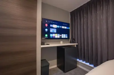 a room with a tv and a bed and a window at inninn HOTEL UENO in Tokyo