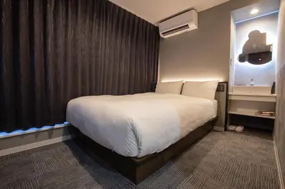 a hotel room with a large bed and a window at inninn HOTEL UENO in Tokyo