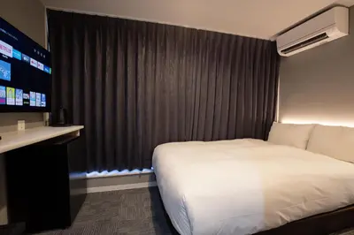a hotel room with a bed and a television at inninn HOTEL UENO in Tokyo