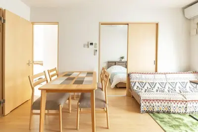a dining room with a table and a bed at Michiko House in Tokyo