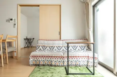 a bedroom with a bed and a table and a window at Michiko House in Tokyo