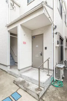 a front door of a building with a staircase and a house at Michiko House in Tokyo