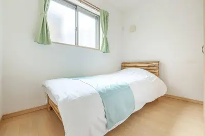 a bed in a room with a window at Michiko House in Tokyo