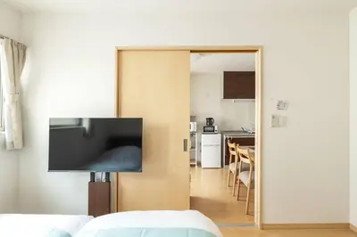 a living room with a television on a wall at Michiko House in Tokyo