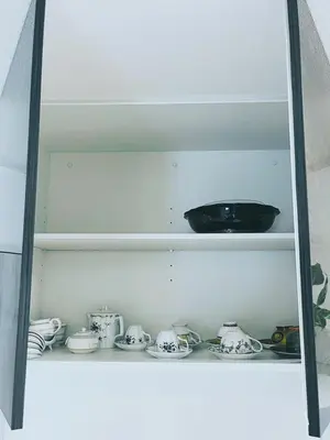 a shelf with dishes and a bowl on it at \u4e0b\u753a\u7acb\u77f3\u99c5\u8fd1\u6c11\u6cca\u7f8e\u5e78 in Tokyo