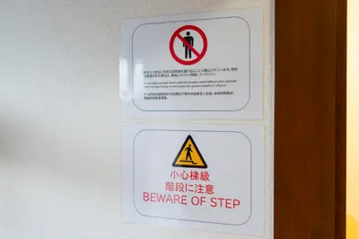 two signs on a door with a beware of step sign at \u6c60\u888b\u672c\u753a\u4e00\u8ed2\u5bb6 \u6700\u59276\u540d WiFi \u5317\u6c60\u888b\u99c5\u5f92\u6b696\u5206 \u6c60\u888b\u99c5\u96fb\u8eca1\u5206 in Tokyo