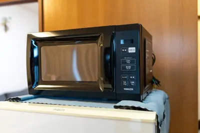 a microwave sitting on top of a refrigerator at \u6c60\u888b\u672c\u753a\u4e00\u8ed2\u5bb6 \u6700\u59276\u540d WiFi \u5317\u6c60\u888b\u99c5\u5f92\u6b696\u5206 \u6c60\u888b\u99c5\u96fb\u8eca1\u5206 in Tokyo