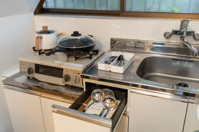 a small kitchen with a stove and a sink at \u6c60\u888b\u672c\u753a\u4e00\u8ed2\u5bb6 \u6700\u59276\u540d WiFi \u5317\u6c60\u888b\u99c5\u5f92\u6b696\u5206 \u6c60\u888b\u99c5\u96fb\u8eca1\u5206 in Tokyo