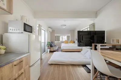a kitchen and living room with a white refrigerator at self-check in-\u65b0\u5927\u4e45\u4fdd\u30de\u30f3\u30b7\u30e7\u30f3 in Tokyo
