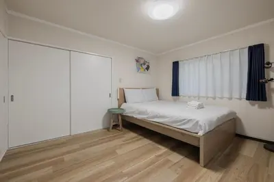 a bedroom with a bed and a large window at self-check in-\u65b0\u5927\u4e45\u4fdd\u30de\u30f3\u30b7\u30e7\u30f3 in Tokyo