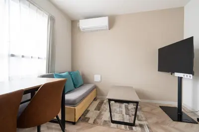 a living room with a couch and a table at CH RESiDENCE \u559c\u4e45\u4e95\u753a in Tokyo