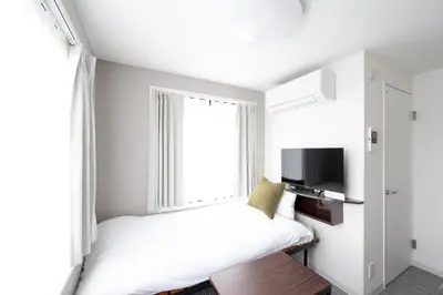 a small bedroom with a bed and a window at CH RESiDENCE \u559c\u4e45\u4e95\u753a in Tokyo