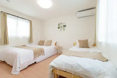 a white room with two beds and a window at \u798f\u5409\u5c4b in Tokyo
