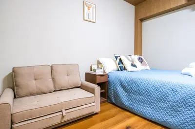 a bedroom with a bed and a couch at Maru 5 Inn in Tokyo