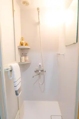 a bathroom with a shower with a glass door at Maru 5 Inn in Tokyo
