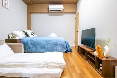 a bedroom with a bed and a flat screen tv at Maru 5 Inn in Tokyo