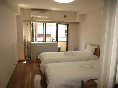 two beds in a small room with a window at \u30e9\u30a4\u30aa\u30f3\u30ba\u30de\u30f3\u30b7\u30e7\u30f3\u9053\u7384\u5742a in Tokyo
