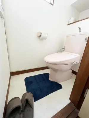 a bathroom with a toilet and a blue rug at \u672c\u753a1\u4e01\u76eeB Honcho 1-chome b in Tokyo