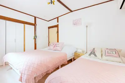 two beds in a room with white walls at \u672c\u753a1\u4e01\u76eeB Honcho 1-chome b in Tokyo