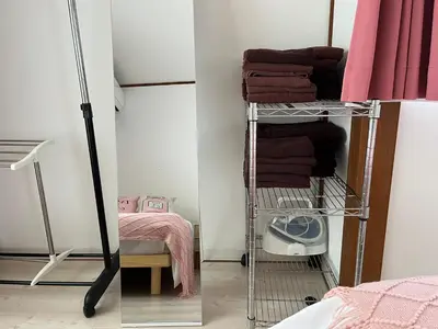 a room with a rack with towels and a bed at \u672c\u753a1\u4e01\u76eeB Honcho 1-chome b in Tokyo
