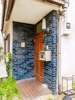 a building with a blue brick wall with a door at \u672c\u753a1\u4e01\u76eeB Honcho 1-chome b in Tokyo