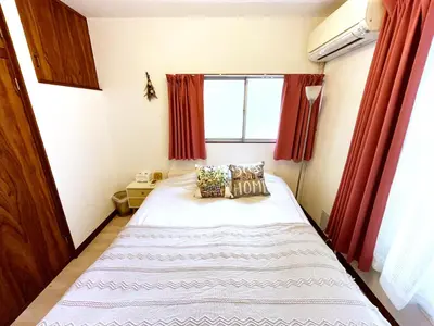 a bedroom with a large bed with red curtains at \u672c\u753a1\u4e01\u76eeB Honcho 1-chome b in Tokyo