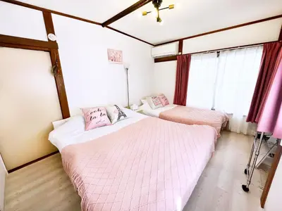 two beds in a room with windows at \u672c\u753a1\u4e01\u76eeB Honcho 1-chome b in Tokyo