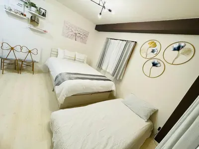 a bedroom with two beds and a table with a chair at Hyakuninchō house NEW OPEN-SJ0067 in Tokyo