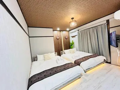 two beds in a small room with a tv at Hyakuninchō house NEW OPEN-SJ0067 in Tokyo