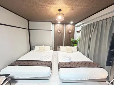 two beds in a small room with a tv at Hyakuninchō house NEW OPEN-SJ0067 in Tokyo