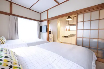 a bedroom with two white beds and a kitchen at \u5922\u306e\u820e\u4ee3\u3005\u6728 Yumenoya Yoyogi in Tokyo