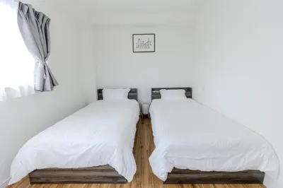 two beds in a room with white walls at a\u5c71\u624b\u7dda\u99d2\u8fbc7\u52064LDK\u30de\u30f3\u30b7\u30e7\u30f391\u5e73\u65b9\u30e1\u30fc\u30c8\u30eb in Tokyo