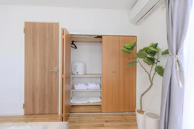 a wooden cabinet with a plant in a room at a\u5c71\u624b\u7dda\u99d2\u8fbc7\u52064LDK\u30de\u30f3\u30b7\u30e7\u30f391\u5e73\u65b9\u30e1\u30fc\u30c8\u30eb in Tokyo