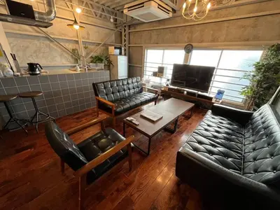 a living room with leather couches and a table at Rakuna Inn \u904a Kinshicho in Tokyo