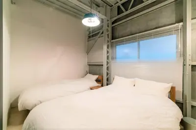 two white beds in a room with a window at Rakuna Inn \u904a Kinshicho in Tokyo